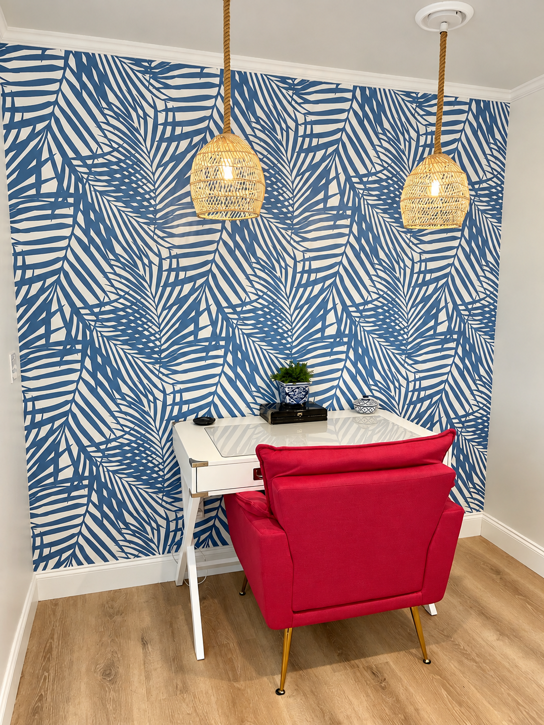 Office workspace with blue palm wallpaper and red chair